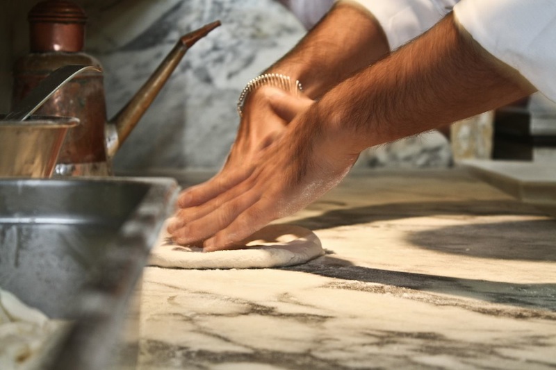 Un-pizzaiolo-mentre-prepara-la-pizza