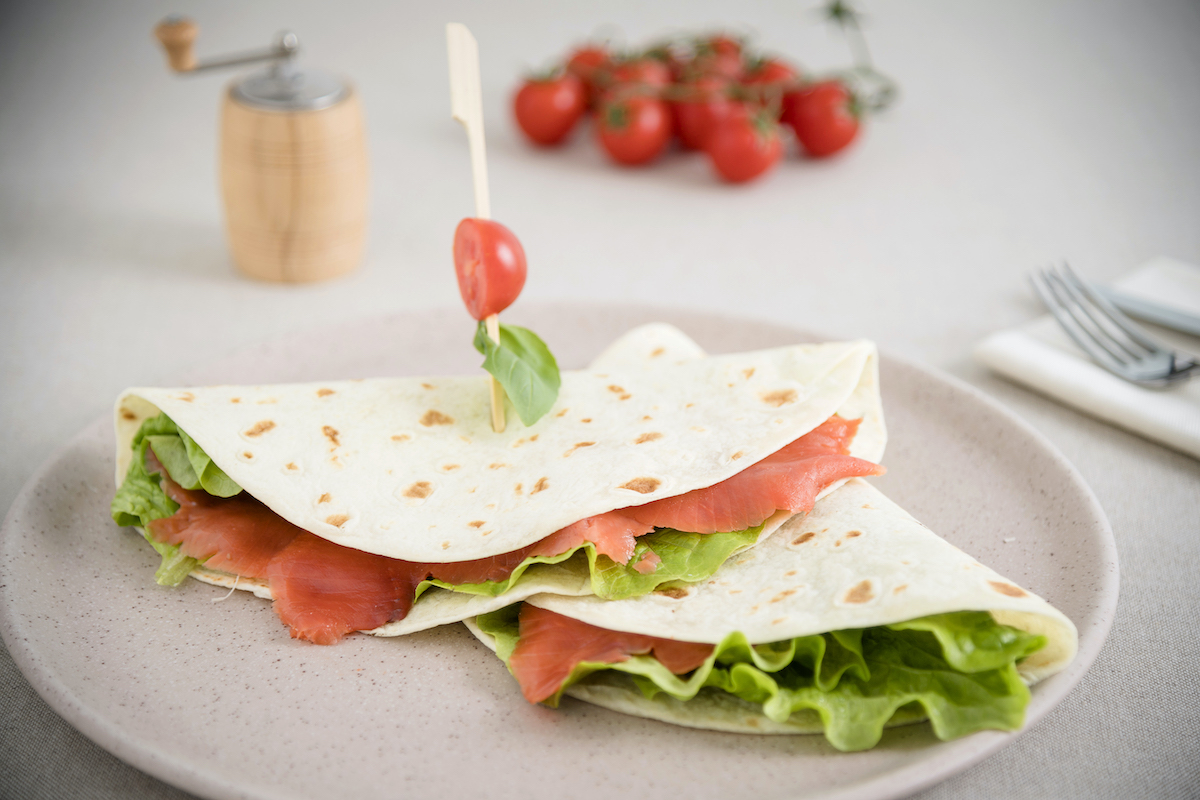 Piadina senza glutine con insalata croccante, salmone affumicato, rondelle pomodoro e basilico