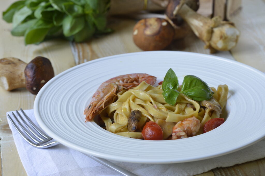 Tagliatelle con porcini, pomodorini scottati e gamberoni